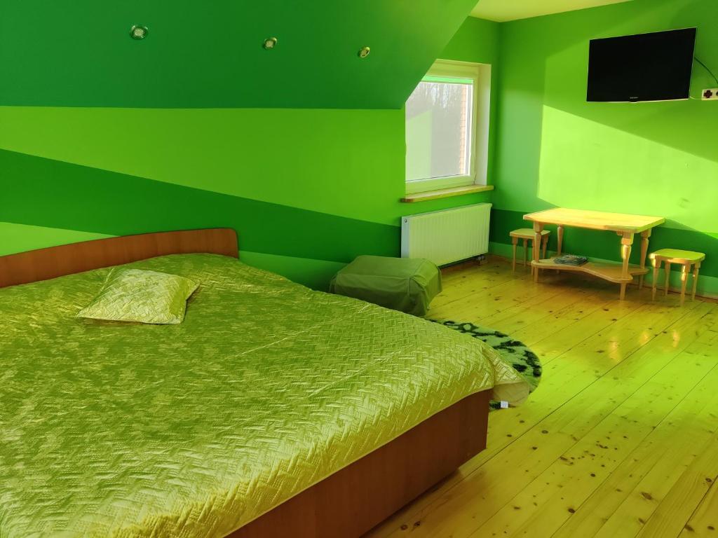 普伦盖Stay at Svaja的绿色卧室配有床和桌子