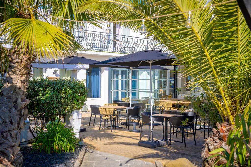 阿尔桑雷玛特里酒店的一个带桌椅和遮阳伞的户外庭院。