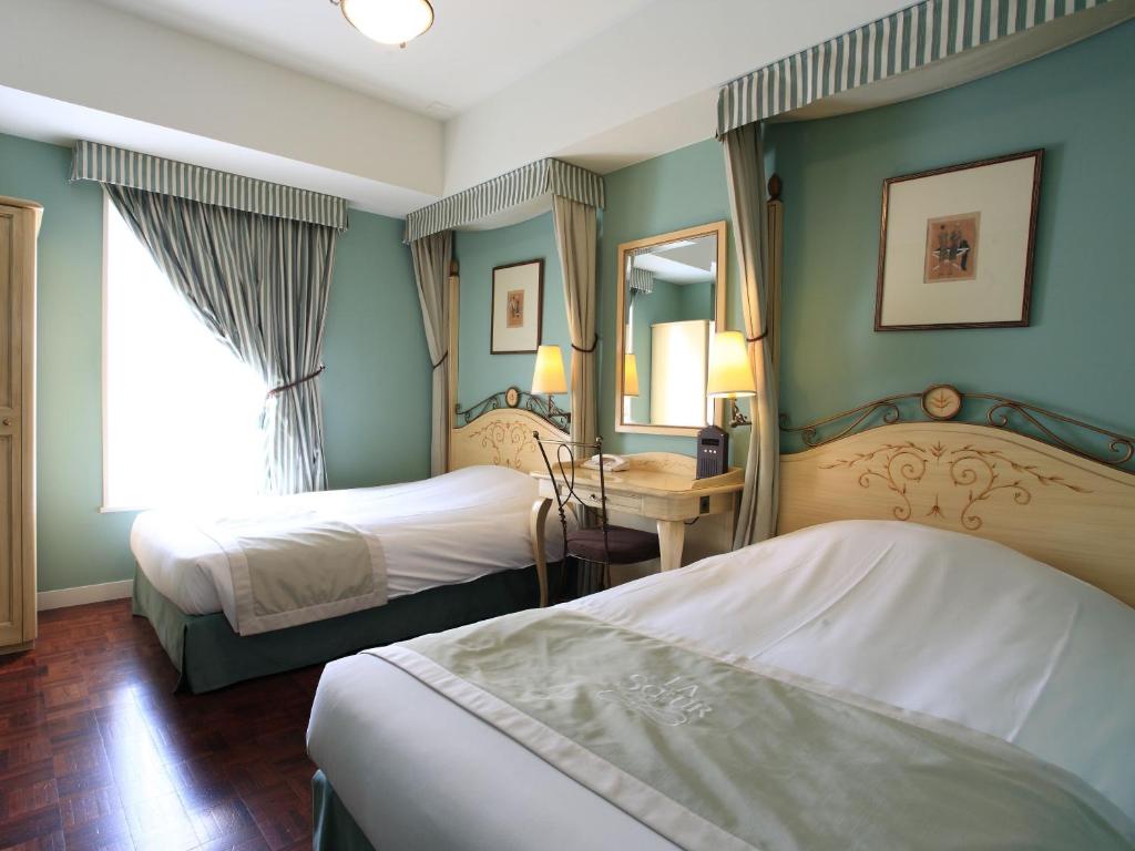 东京银座蒙特利拉苏瑞酒店的酒店客房,设有两张床和镜子