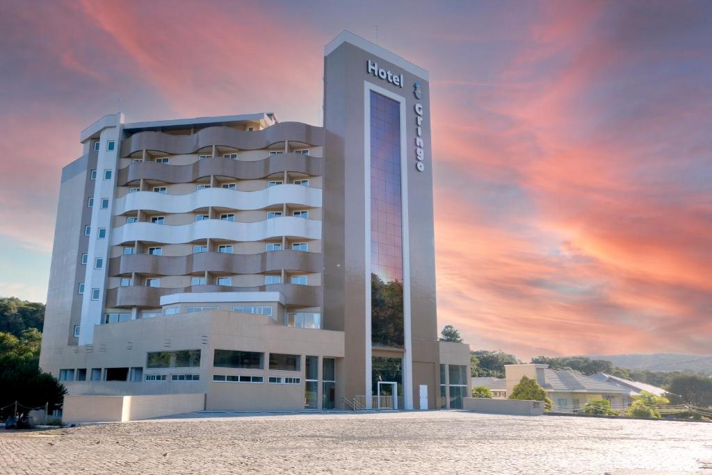 Erval VelhoHotel do Gringo的日落景象的酒店建筑的 ⁇ 染