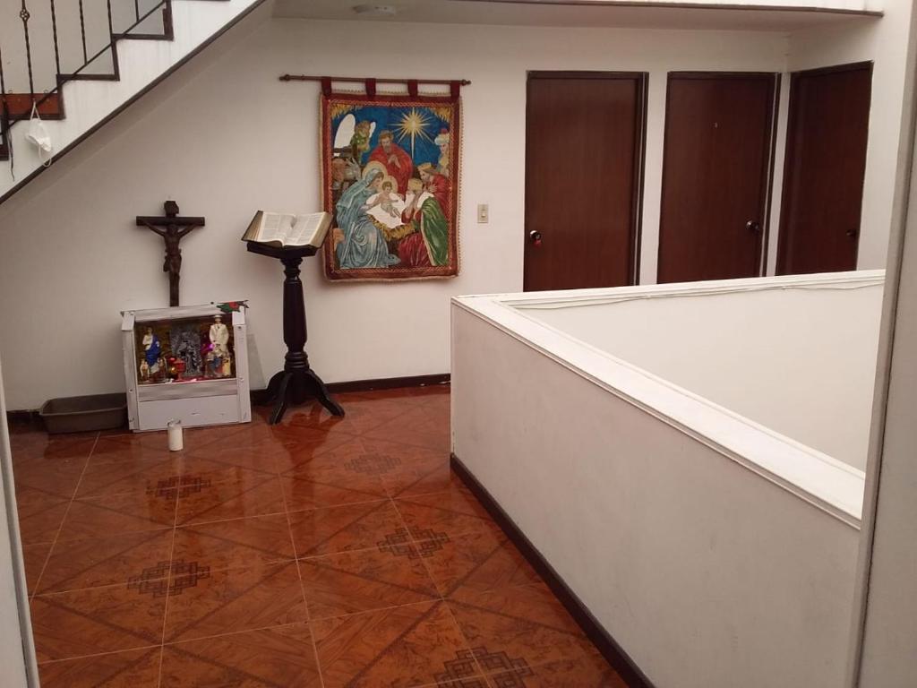 波哥大Habitación con baño privado cerca al aeropuerto的墙上有十字架和绘画的房间
