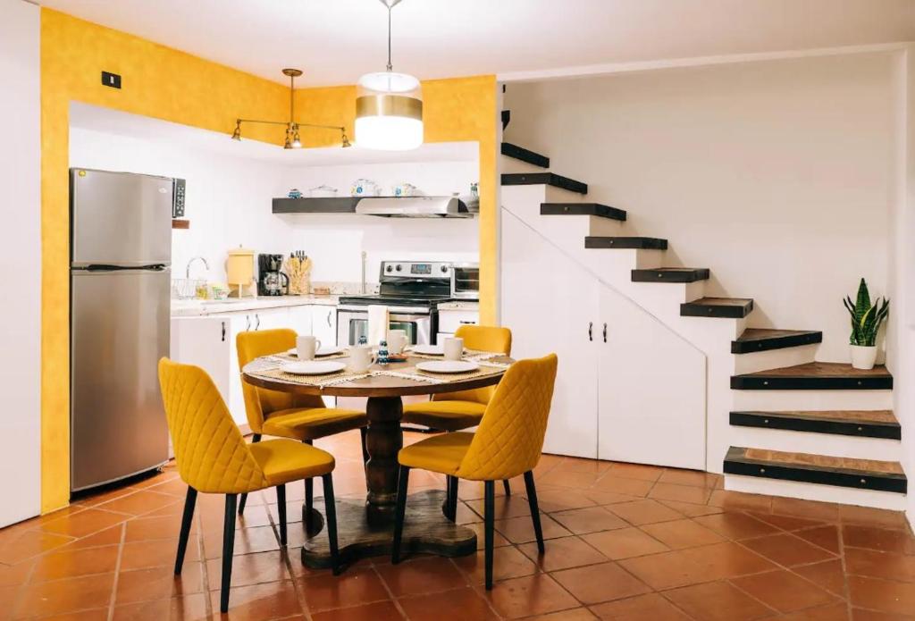 危地马拉安地瓜Villa Santa Inés的厨房以及带桌子和黄色椅子的用餐室。