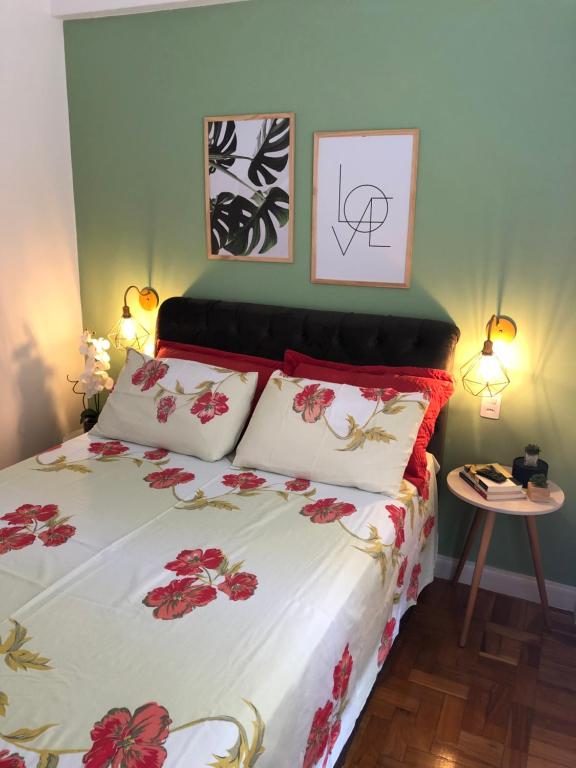 彼得罗波利斯Apartamento Centro Histórico de Petrópolis 200Mbps de internet的一间卧室,床上有红色的鲜花