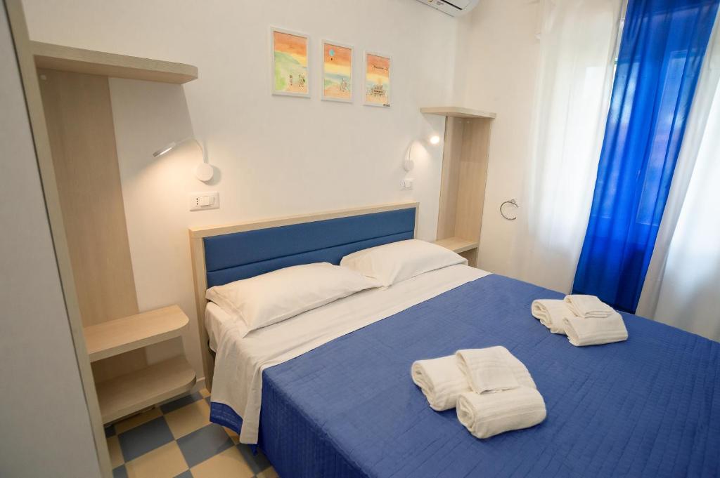 努马纳EDEN CONERO Camere Numana Centro的一间卧室配有蓝色的床和2条毛巾