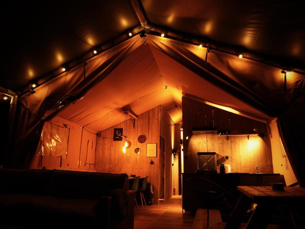 韦斯特卡佩勒Glamped - Luxe camping的一间天花板和灯的房间