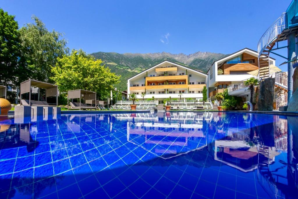 纳图尔诺Familien-Wellness Residence Tyrol的一座大型游泳池,位于部分建筑前