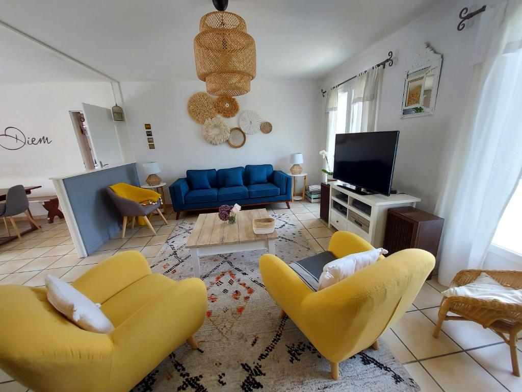 朗通Chambres d'Hotes des Ecureuils的客厅配有黄色椅子和蓝色沙发