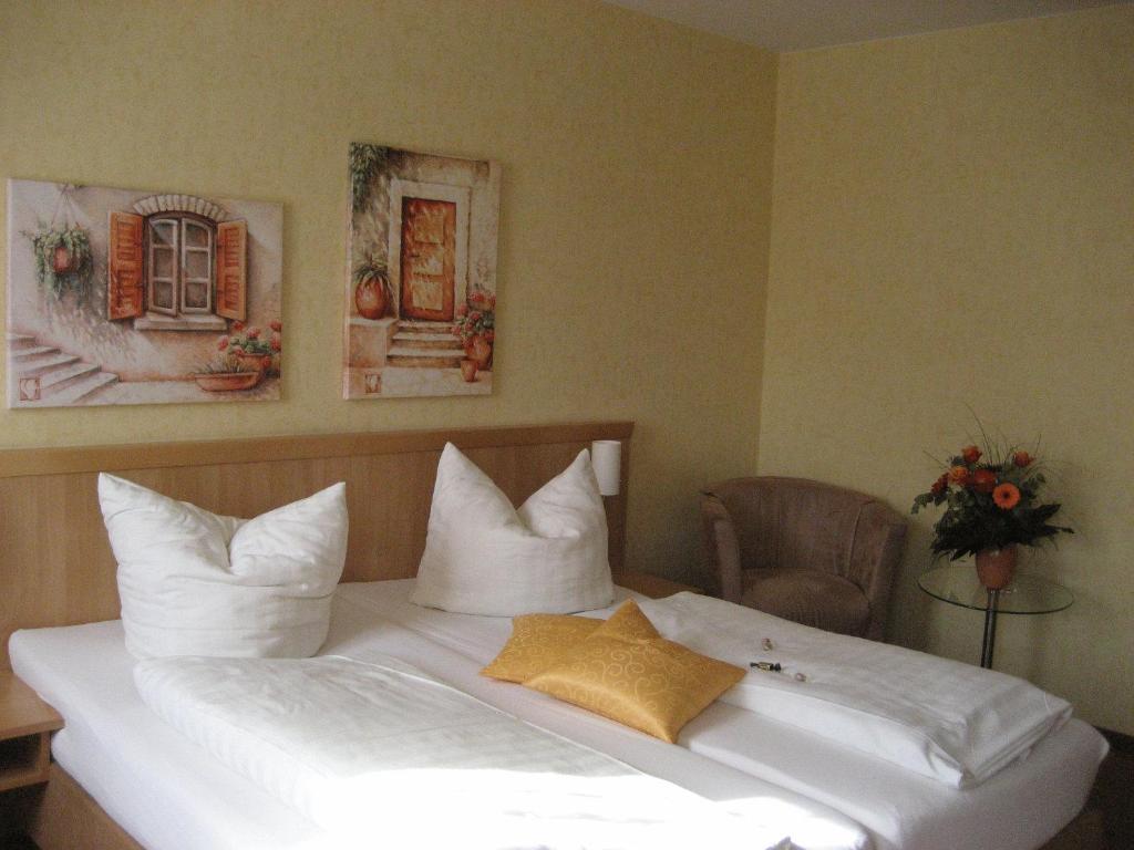 阿尔特廷阿尔施塔特舍科斯酒店的一张带白色床单和枕头的床