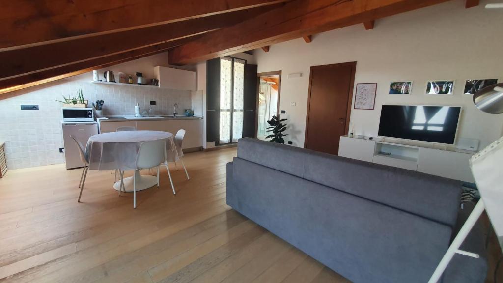 蒙福特达尔巴Appartamento Residenza Lavinia的厨房以及带桌子和电视的客厅。