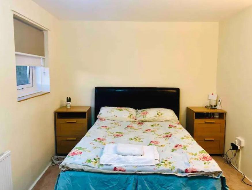 卢顿Private room 4-5 minutes drive to Luton Airport的一间卧室配有床和2个床头柜