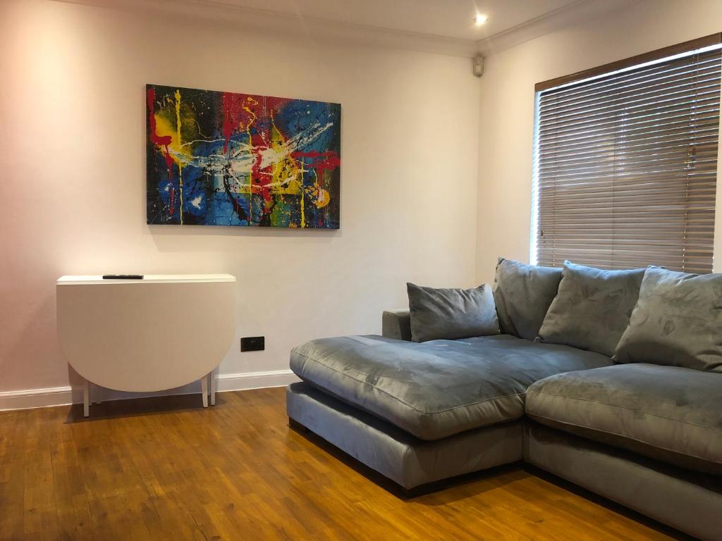珀斯Lovely 1-bedroom flat near city centre的客厅配有沙发和墙上的绘画