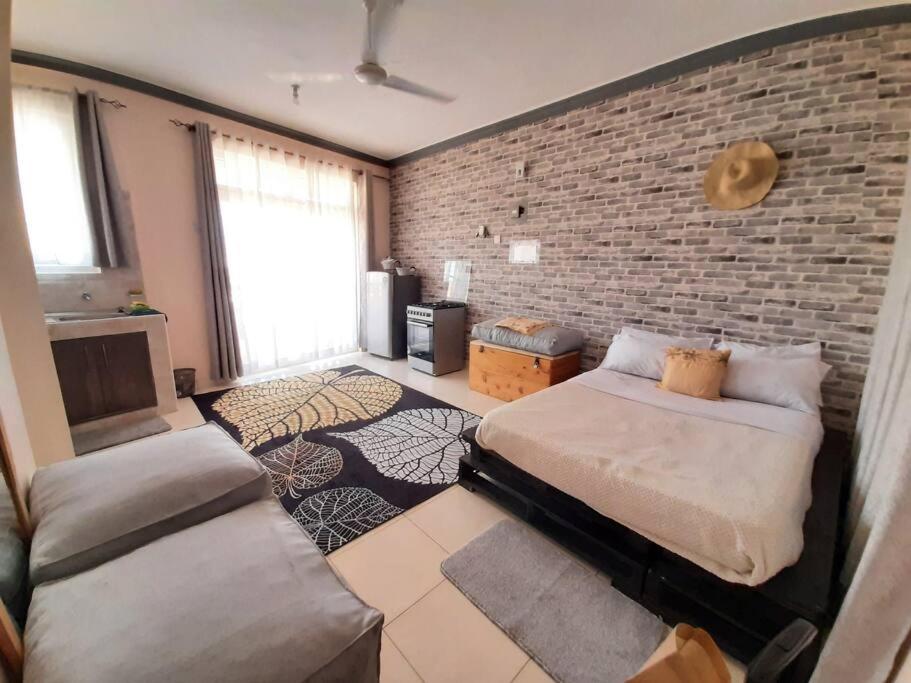 Mto PangaMacy's Studio Apartment的一间卧室设有一张床和砖墙