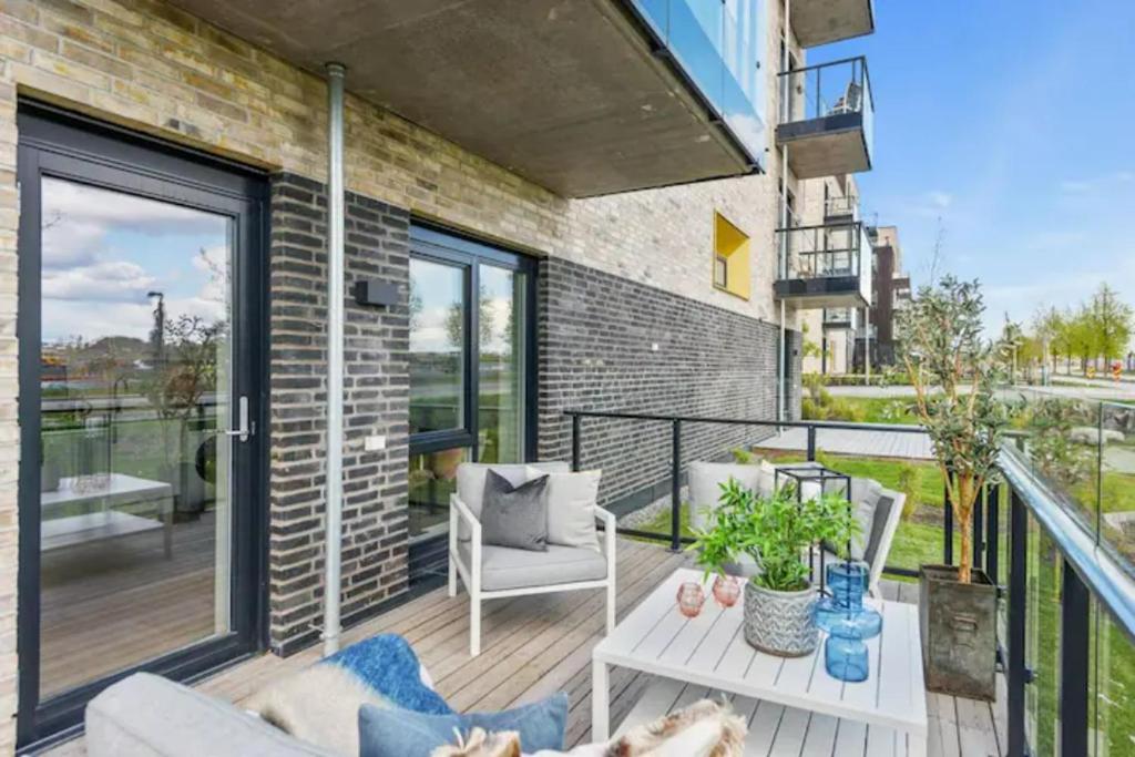 StabekkScandpoint Apartment Fornebu Near Sea front with outdoor walk!的阳台配有沙发和桌子。