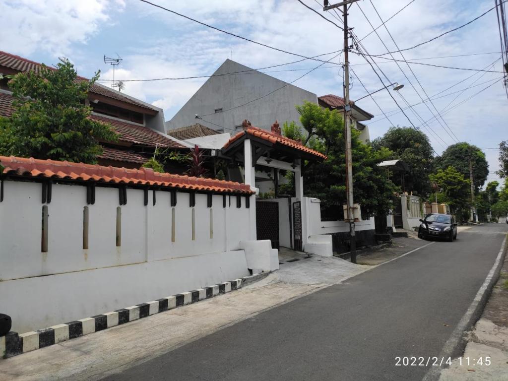 三宝垄Kelana 2 Nice Homestay (5 Bed Rooms) Semarang的一条有白色墙壁和汽车的街道