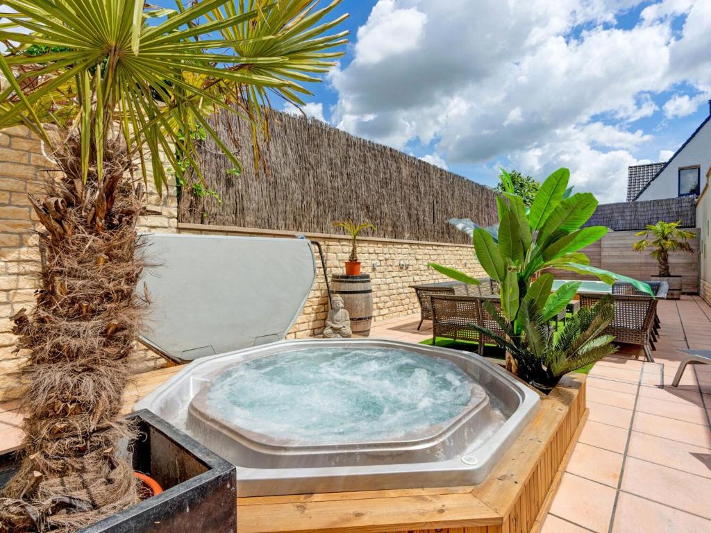 阿纲尔赫姆Lush holiday home with spa and wellness的棕榈树庭院内的热水浴池