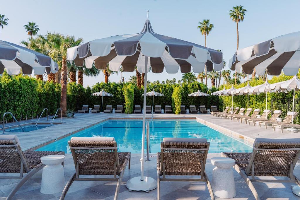 棕榈泉Azure Sky Hotel - Adults Only的毗邻度假酒店的带椅子和遮阳伞的游泳池