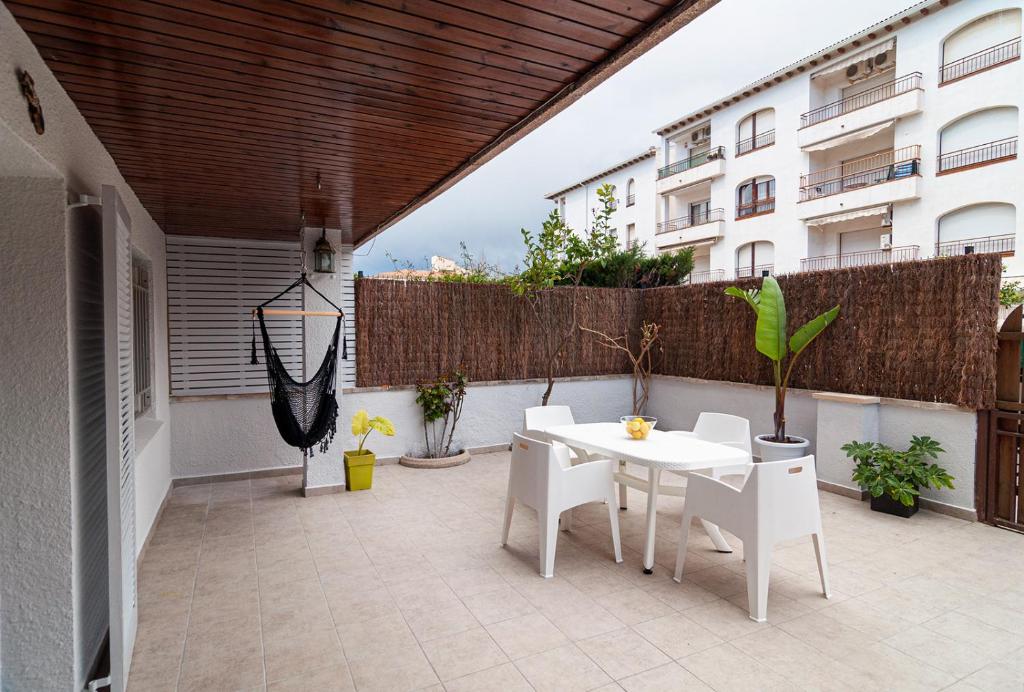 科马鲁加Near beaches large private patio, aircon & community pool的庭院配有白色的桌子和白色的椅子