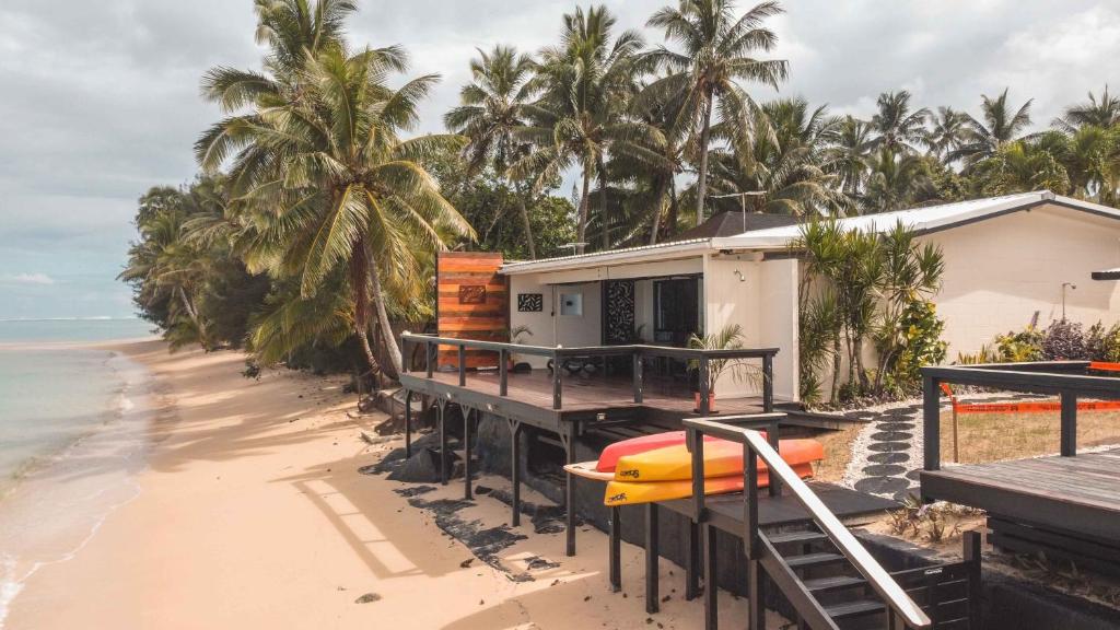 拉罗汤加Take-A-Break Islander on the Beach Villa - Vaimaanga的海滩上的房子,码头上设有冲浪板