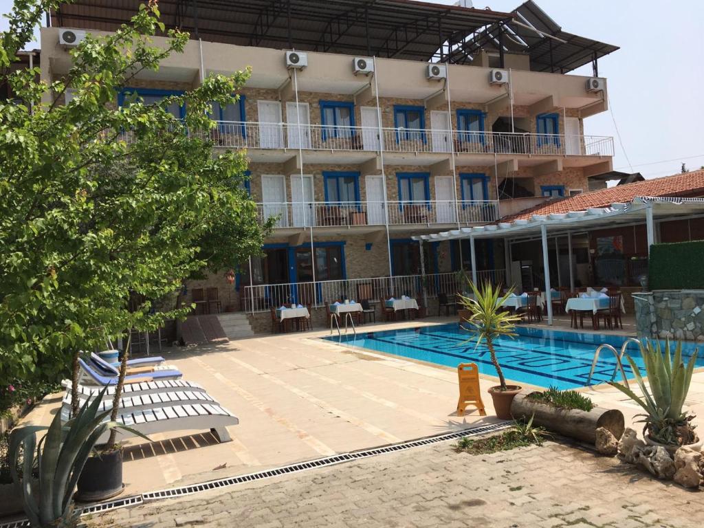 帕莫卡莱shah sultan Ozturk Hotel的大楼前设有游泳池的酒店