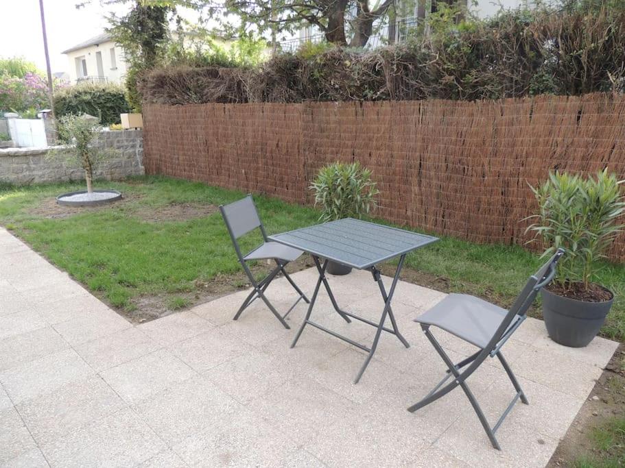 蓬托尔松Appartement entre terre et baie的后院的一张野餐桌和两把椅子