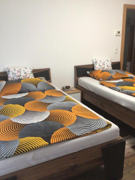 维也纳新城Nina Apartment的两张睡床彼此相邻,位于一个房间里