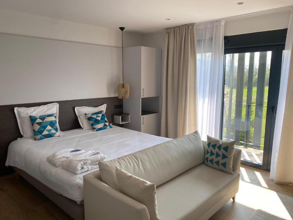 圣奈Villa Thermae Santenay的卧室配有白色的床和沙发