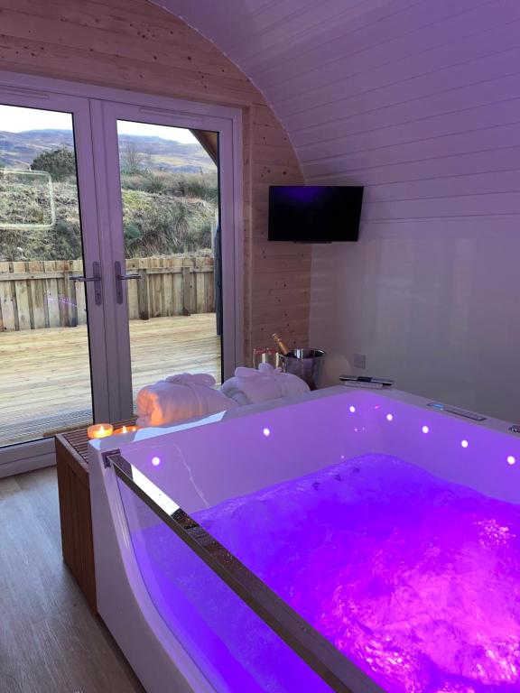 威廉堡Apex Studio Pod & Jacuzzi Bath的窗户客房内的大紫色浴缸