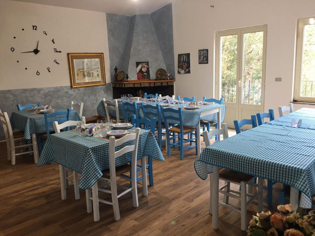 AustisAZIENDA AGRITURISTICA S'ARGALASI - B&B - AFFITTACAMERE Loc S'Argalasi Austis的一间配备有蓝色桌椅和时钟的餐厅