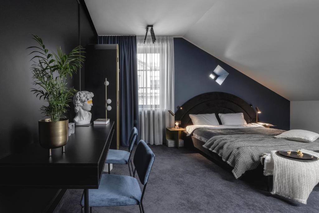 考纳斯Berman House的一间卧室配有一张床、一张桌子和一张植物桌子