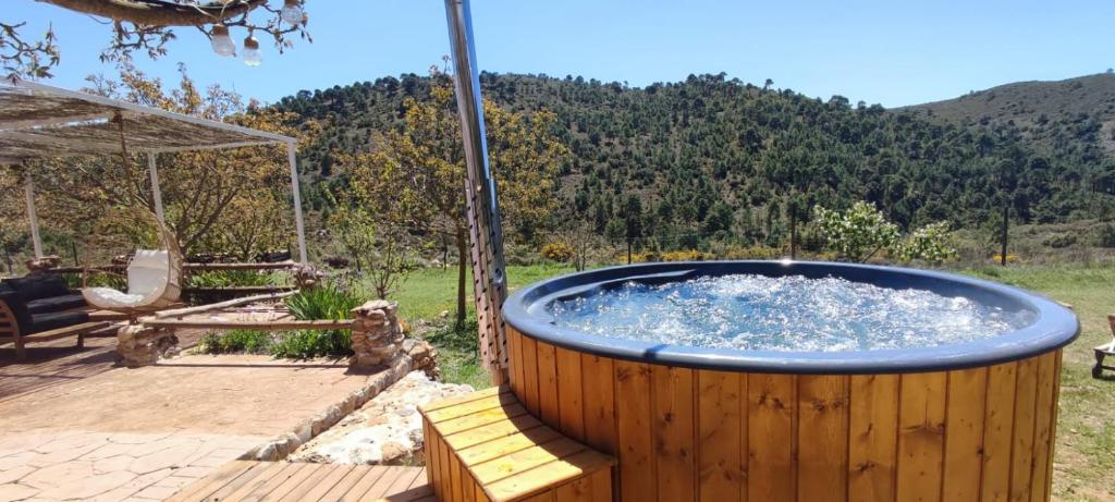 阿尔姆尼卡Esencia Lodge - luxurious off-grid cabin retreat的木制甲板上的大型热水浴池