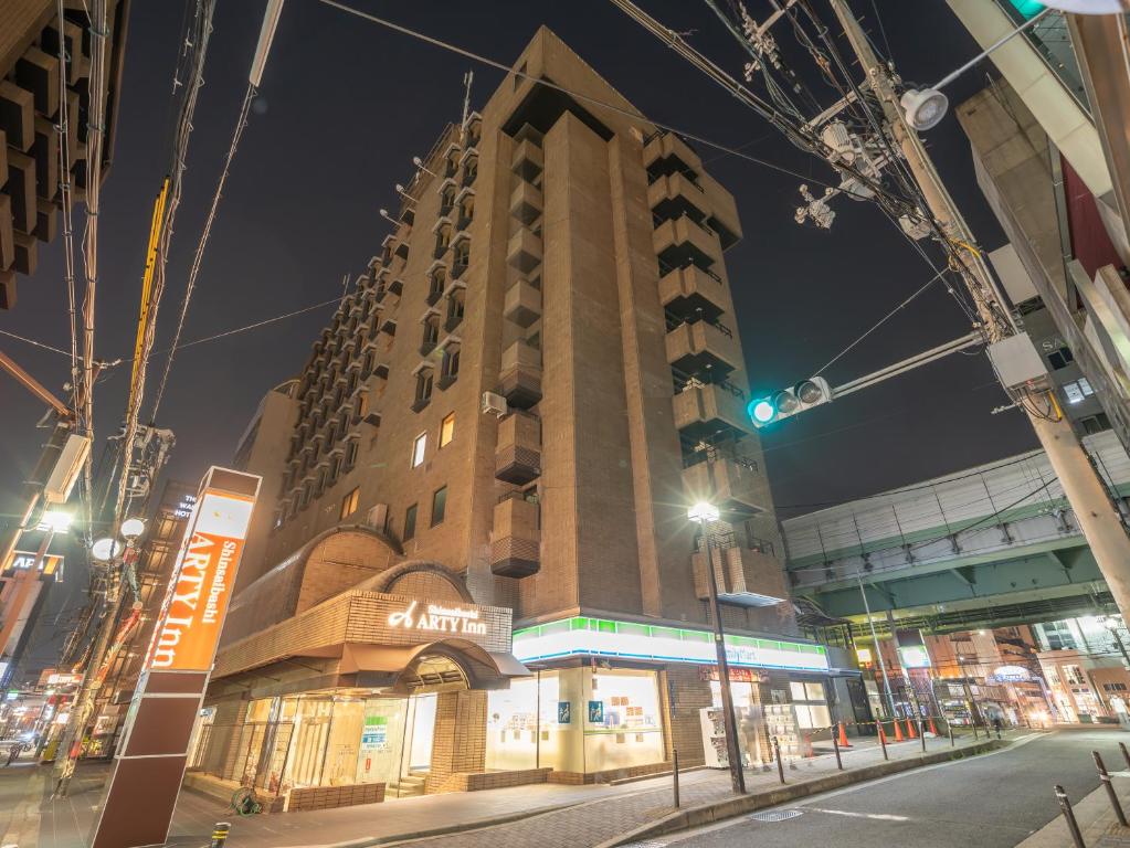 大阪Shinsaibashi ARTY Inn的夜幕降临的城市街道上一座高楼