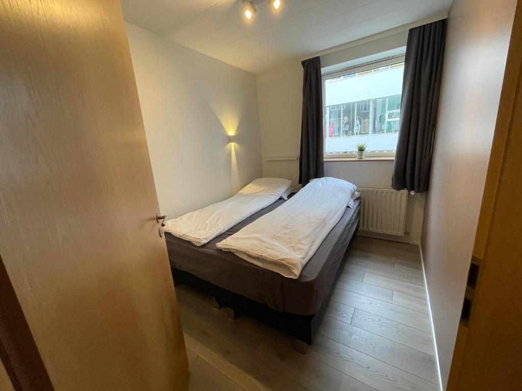 阿克雷里Saga Apartments Akureyri的一间小卧室,配有床和窗户