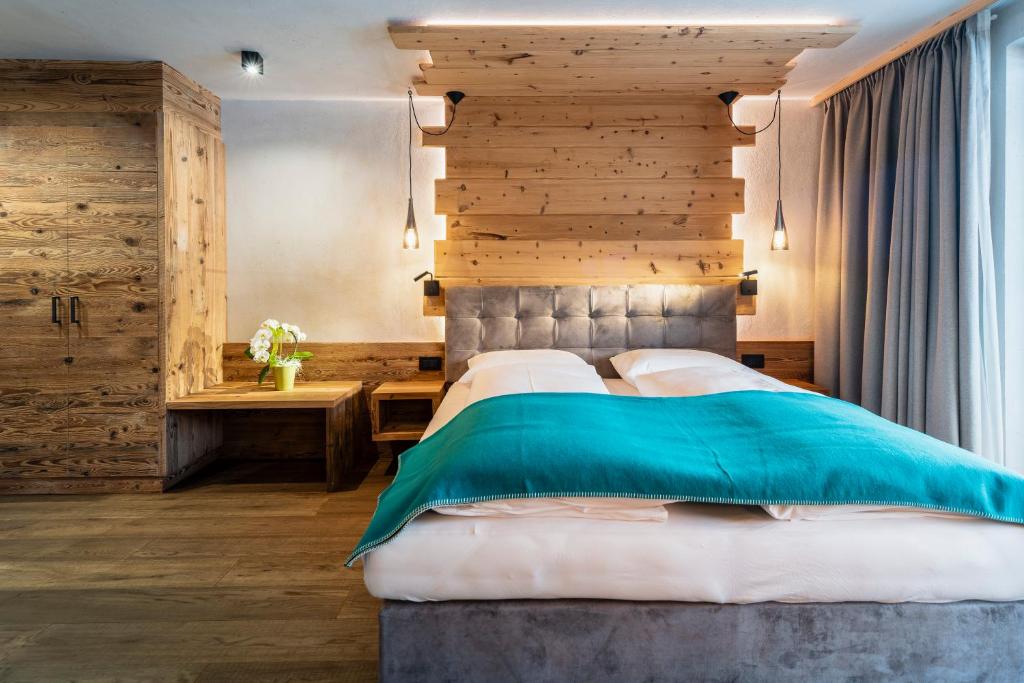 安特尔莫伊亚Garni Mia Co的一间卧室设有一张大床和木墙