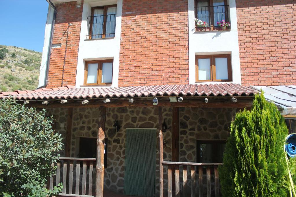 拿瓦费彼迪亚-德科尔Las Tejeruelas Casa Rural的一座带绿门和窗户的房子
