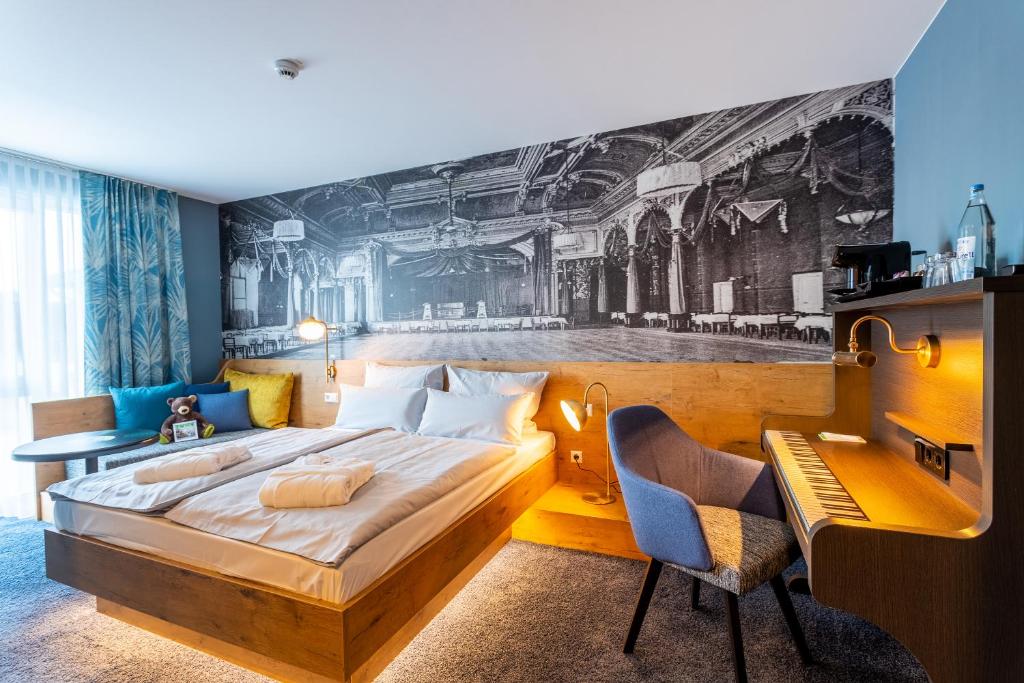 德累斯顿mightyTwice Hotel Dresden的一间卧室配有一张大床、一张桌子和一张书桌