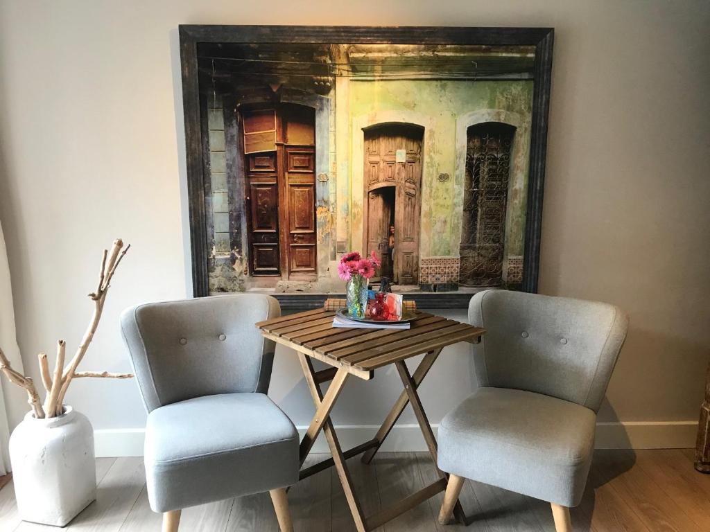 赞德沃特Studio Pipper的一张桌子、两把椅子和墙上的一幅画