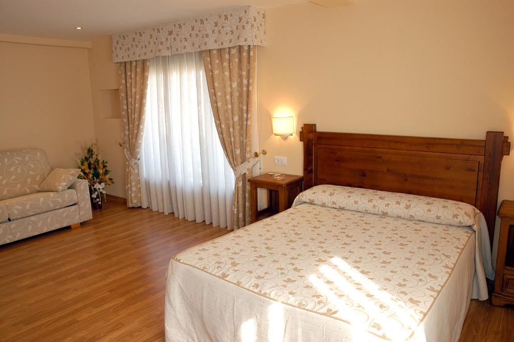 El Grado特雷斯卡米尼奥斯公寓酒店的一间卧室配有一张床和一张沙发
