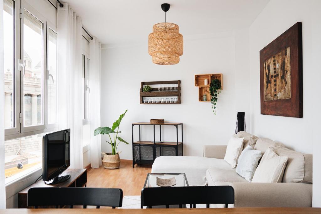 巴塞罗那Sunny and modern apartment ideal for groups的带沙发和电视的白色客厅