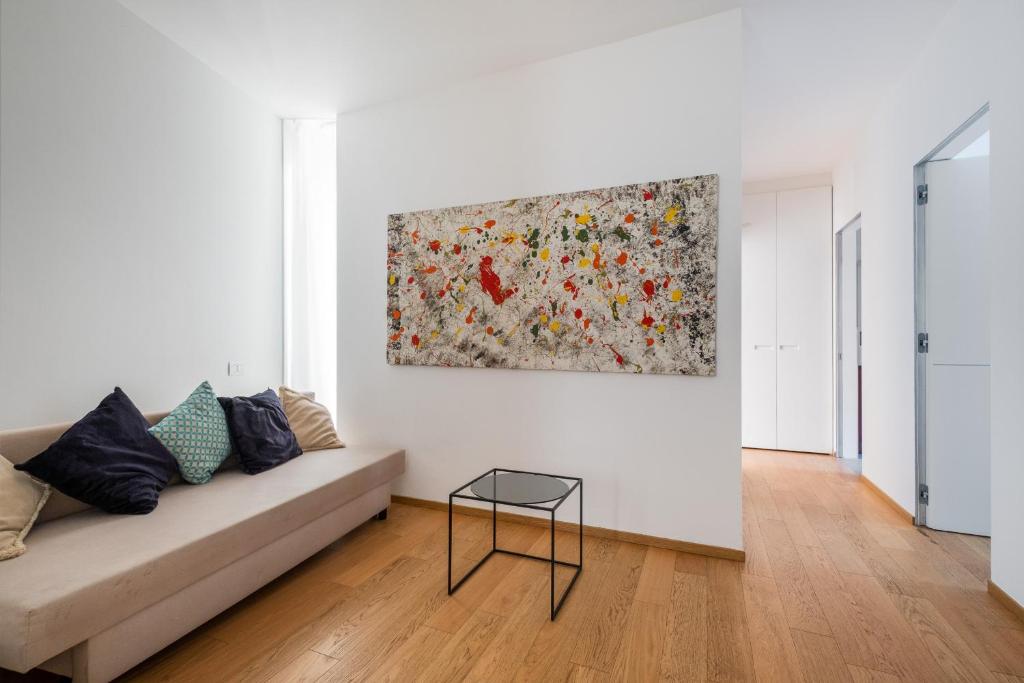博洛尼亚Santo Stefano Design Apartment by Wonderful Italy的客厅配有沙发和墙上的绘画