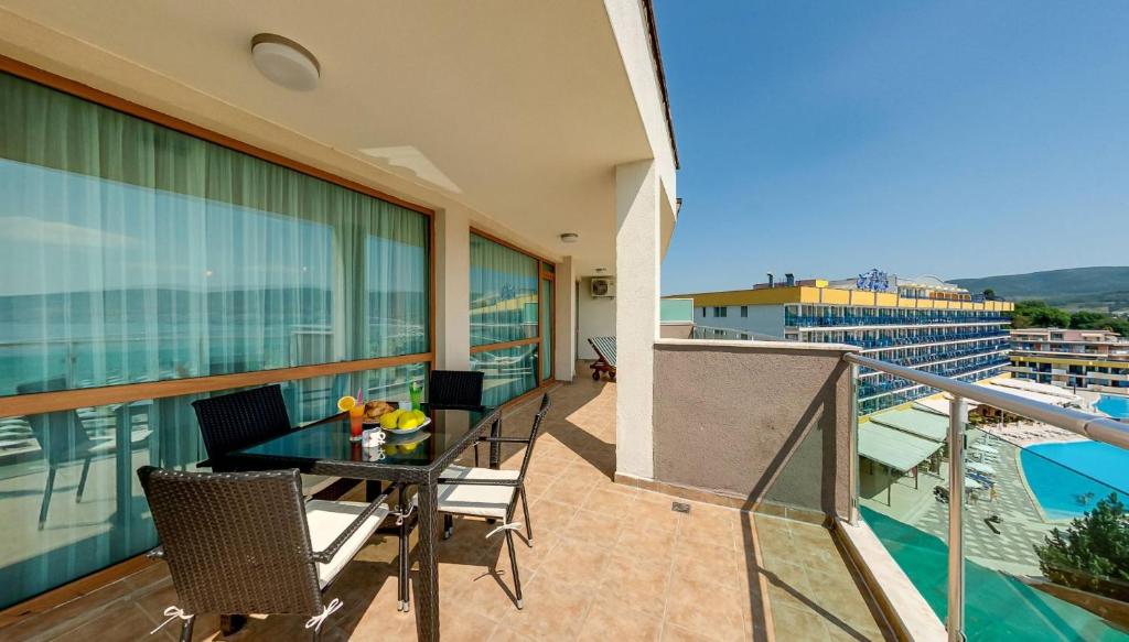阳光海滩Briz Beach Apartments的大楼内的阳台配有桌椅