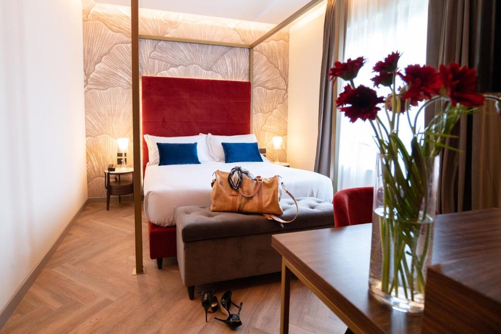 伊夫雷亚3T Boutique Hotel的配有一张床和花瓶的酒店客房