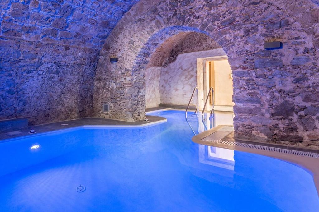 Montesano sulla MarcellanaPalazzo Cestari Hotel的一座石头墙建筑中的一个大型游泳池
