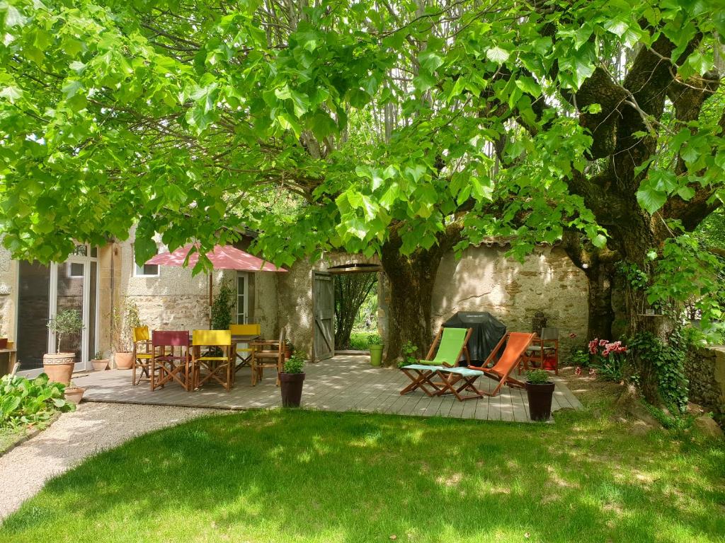 罗曼内切·托林斯VILLA VILLOU的树下带桌椅的庭院