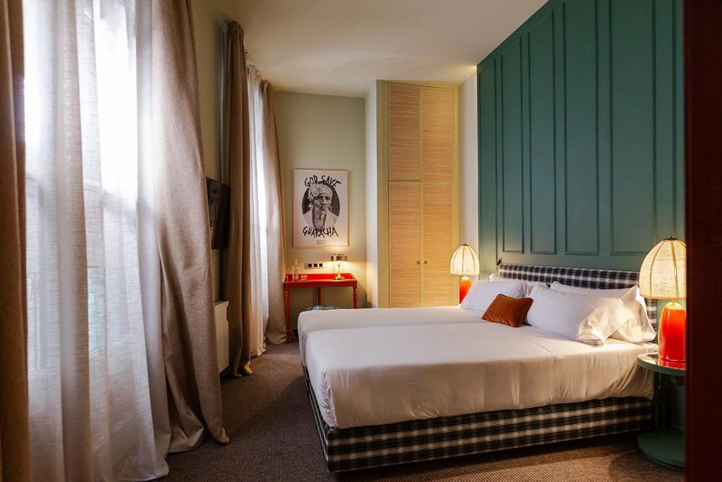 巴塞罗那chic&basic Habana Hoose的一间卧室设有一张床和绿色的墙壁