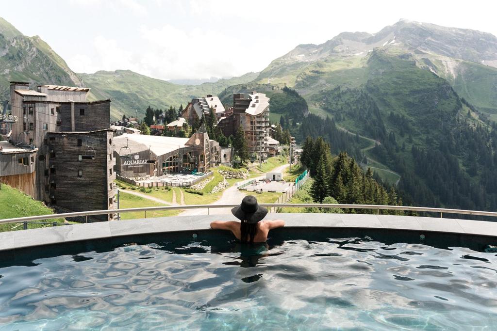 阿沃里亚兹Hôtel MiL8的山景热水浴池中的一个人