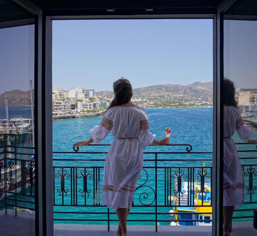 阿基欧斯尼古拉斯Casa Porto Boutique Hotel - Adults only的两个女人站在一个阳台上望着水面