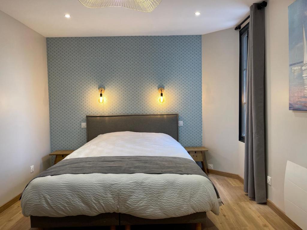 滨海图维列Villa Madeleine rénovée plage hyper centre的一间卧室配有一张带蓝色壁纸的大床