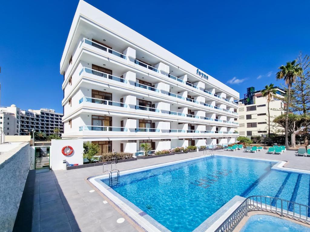 英格兰海滩Apartamentos Fayna的大楼前设有游泳池的酒店