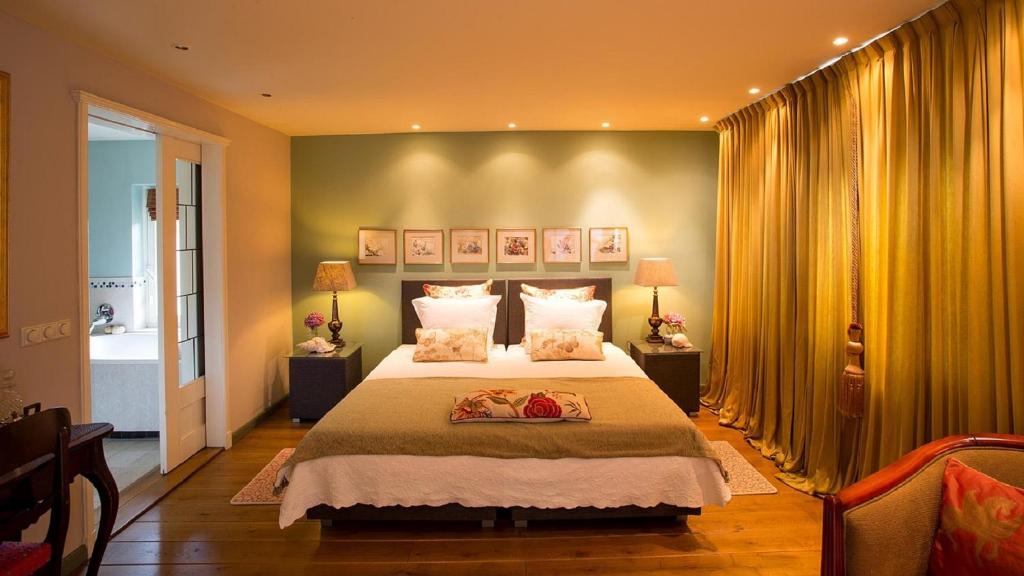 Schijndel斯海德尔豪华住宿加早餐旅馆的一间卧室配有大床和黄色窗帘
