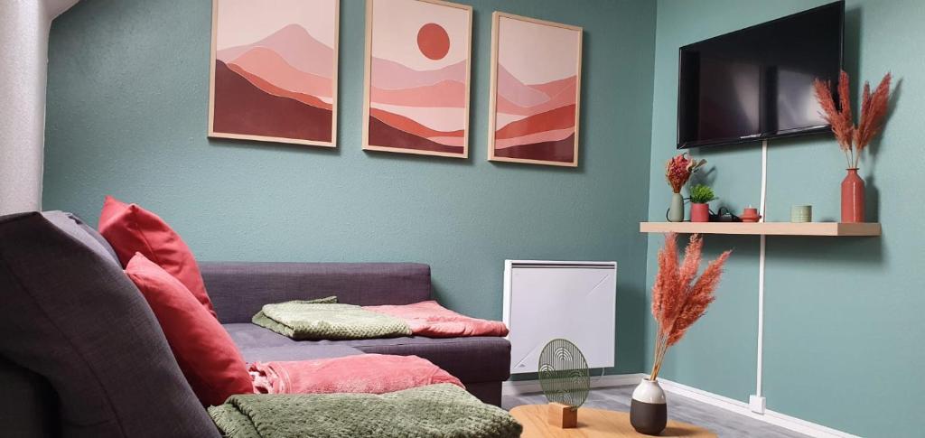 乌伊斯特勒昂Stigi, duplex de standing à 100m de la mer的客厅配有紫色沙发和绘画作品